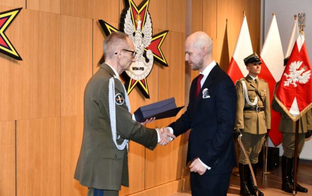Grzegorz Gielerak wręcza pracownikowi WIM dyplom.