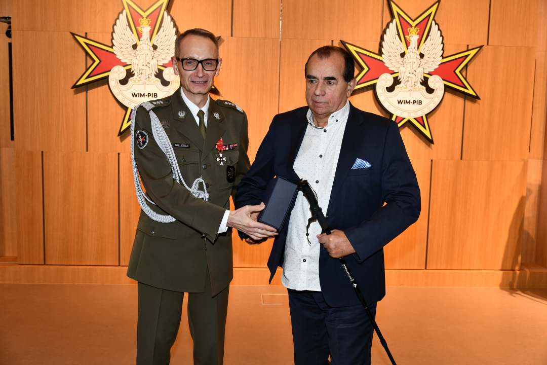 Dyrektor WIM pozuje do zdjęcia z laureatem.